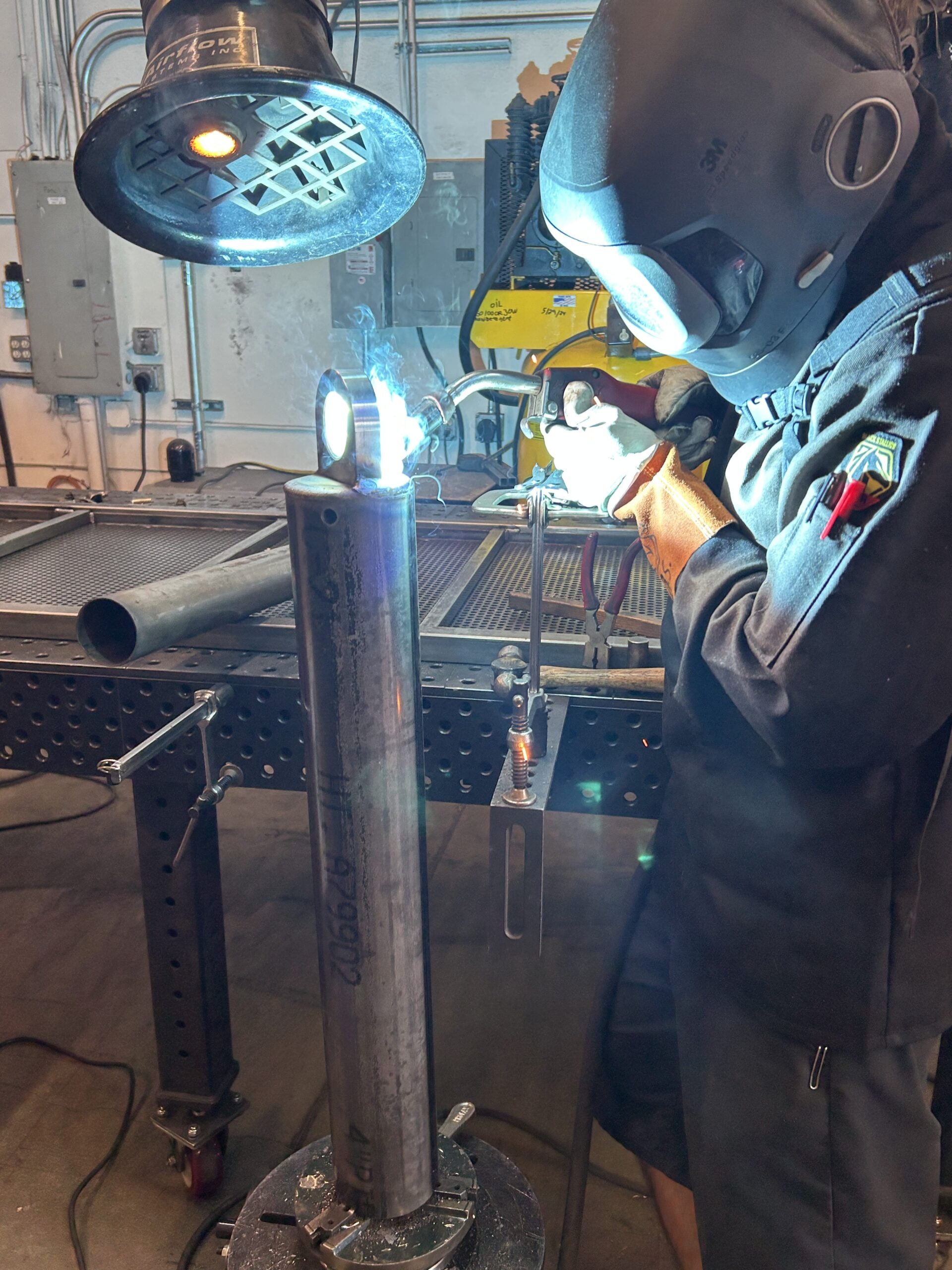 welder finishing a custom fabricated tieback anchor