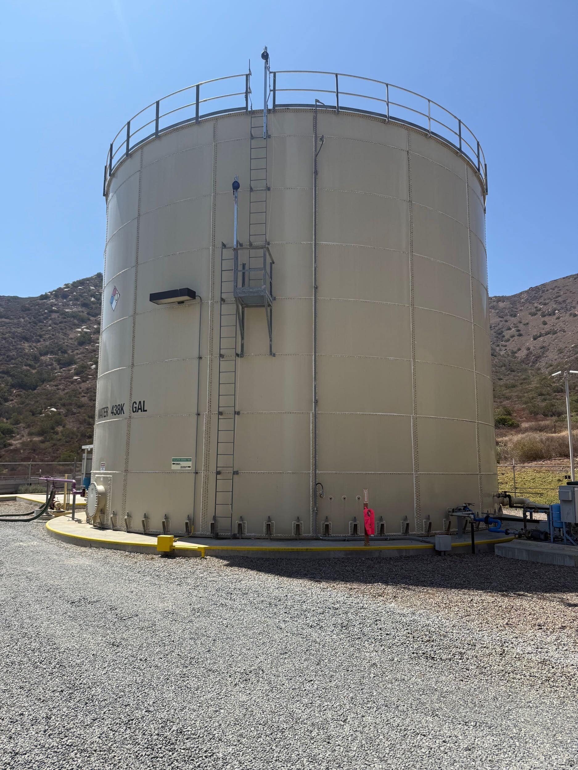 Fixed access ladder and guardrail platform on large wastewater storage tank