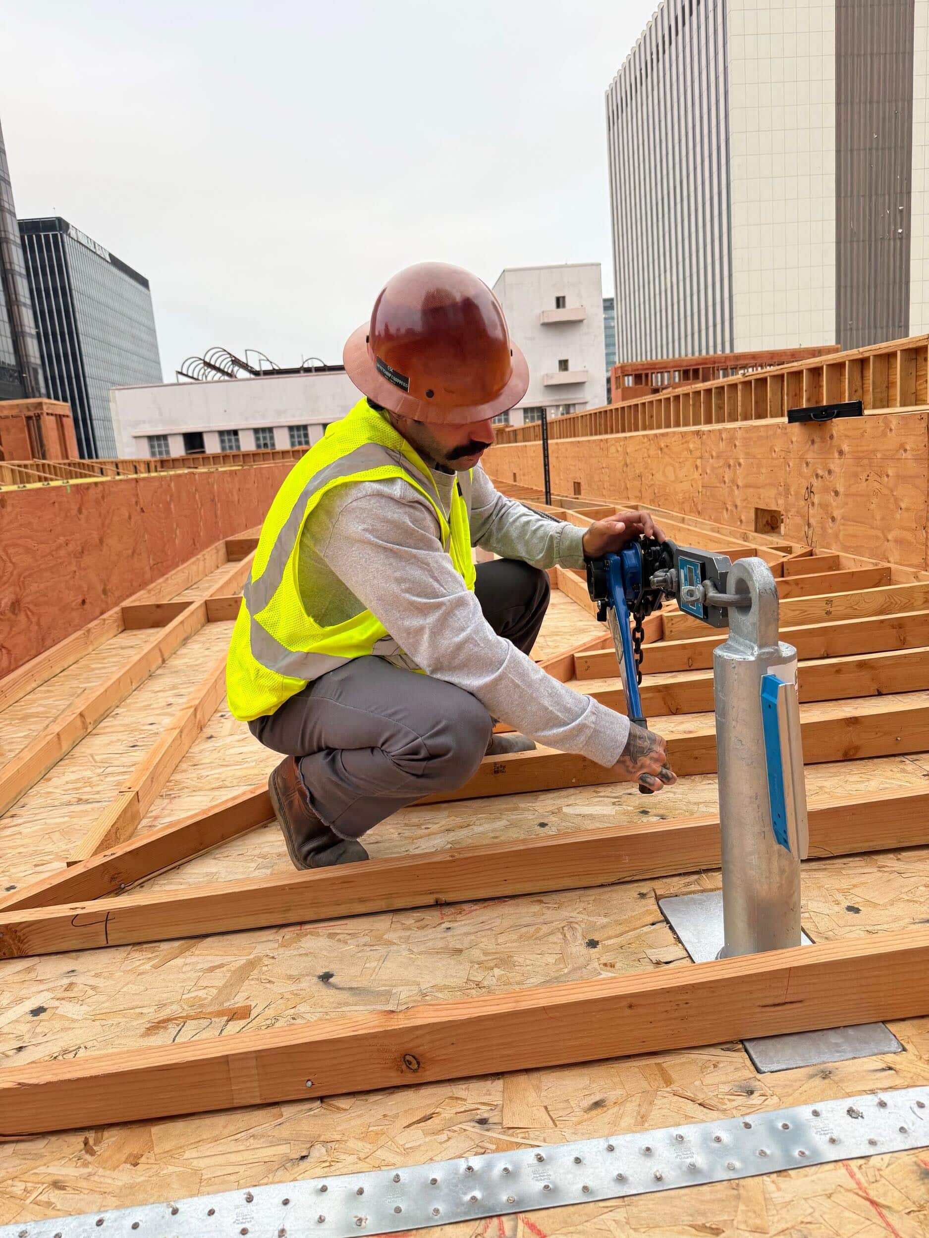 Worker installing a roof tieback anchor